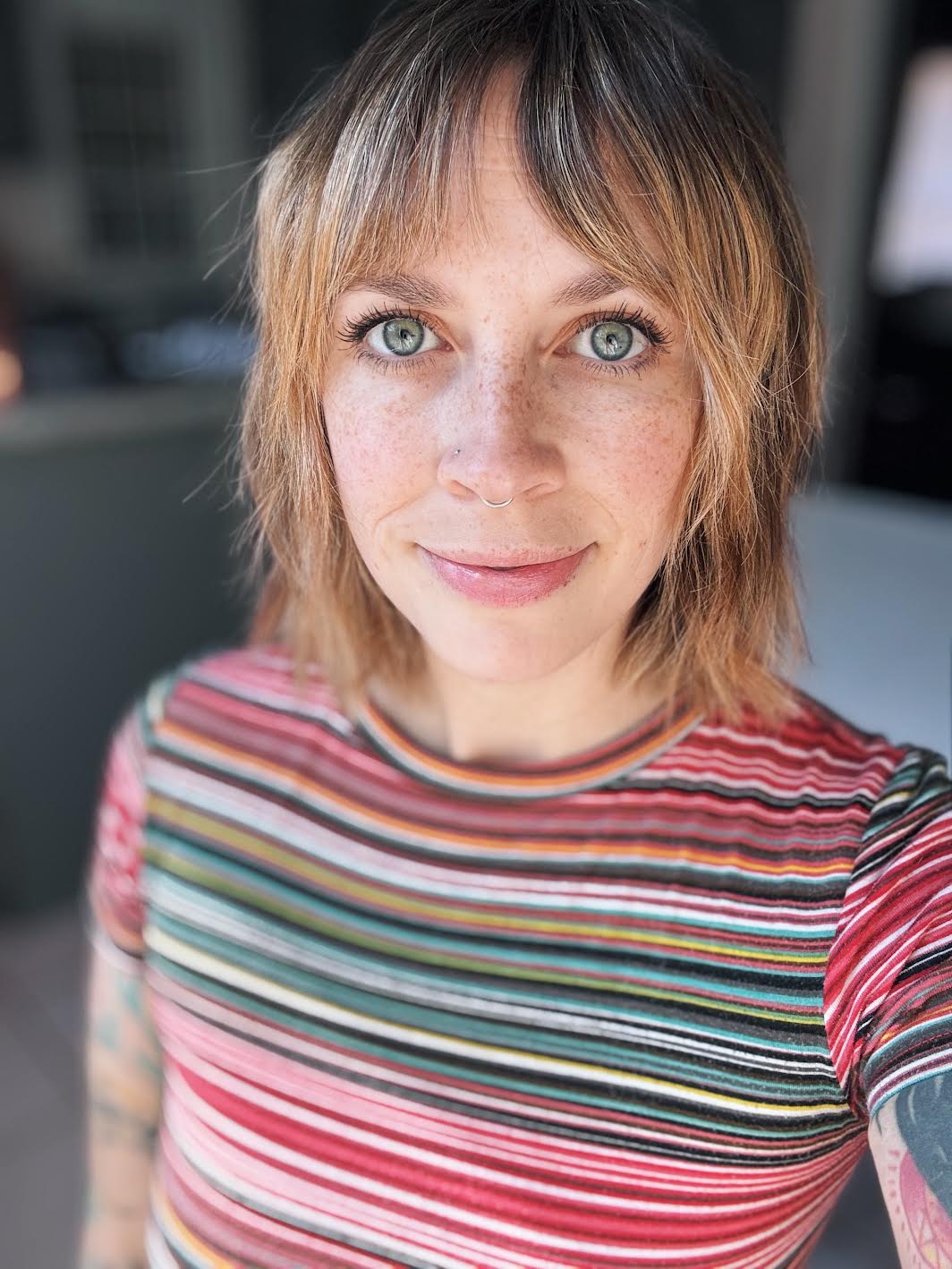 Person wearing a colorful striped shirt with a blurred background