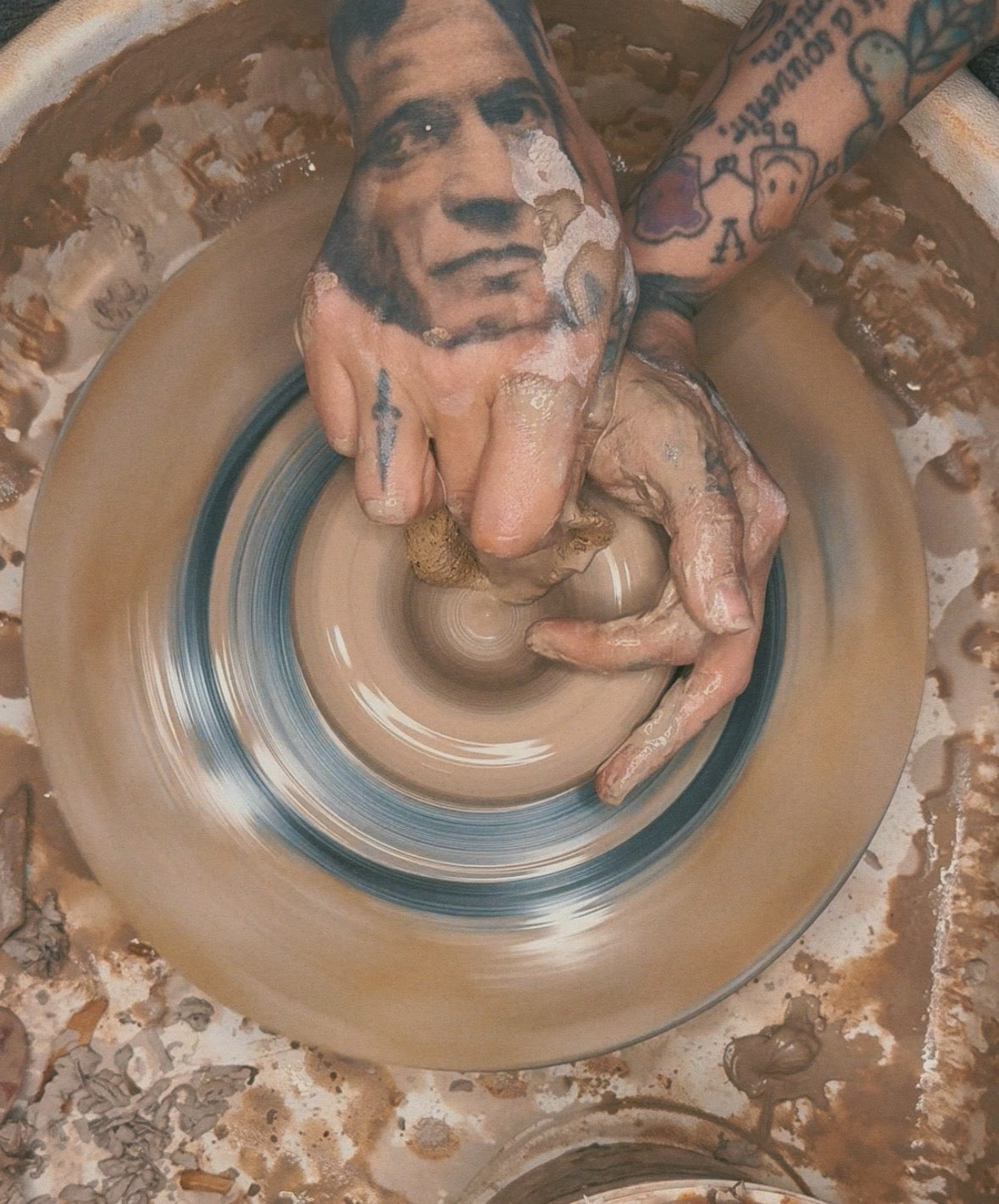 Person's hands working with clay on a potter's wheel